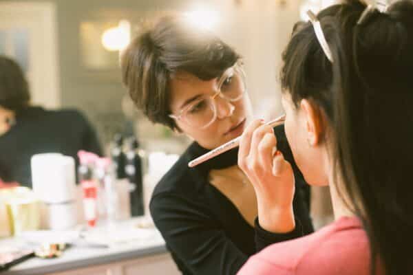 woman applying makeup to another woman's face